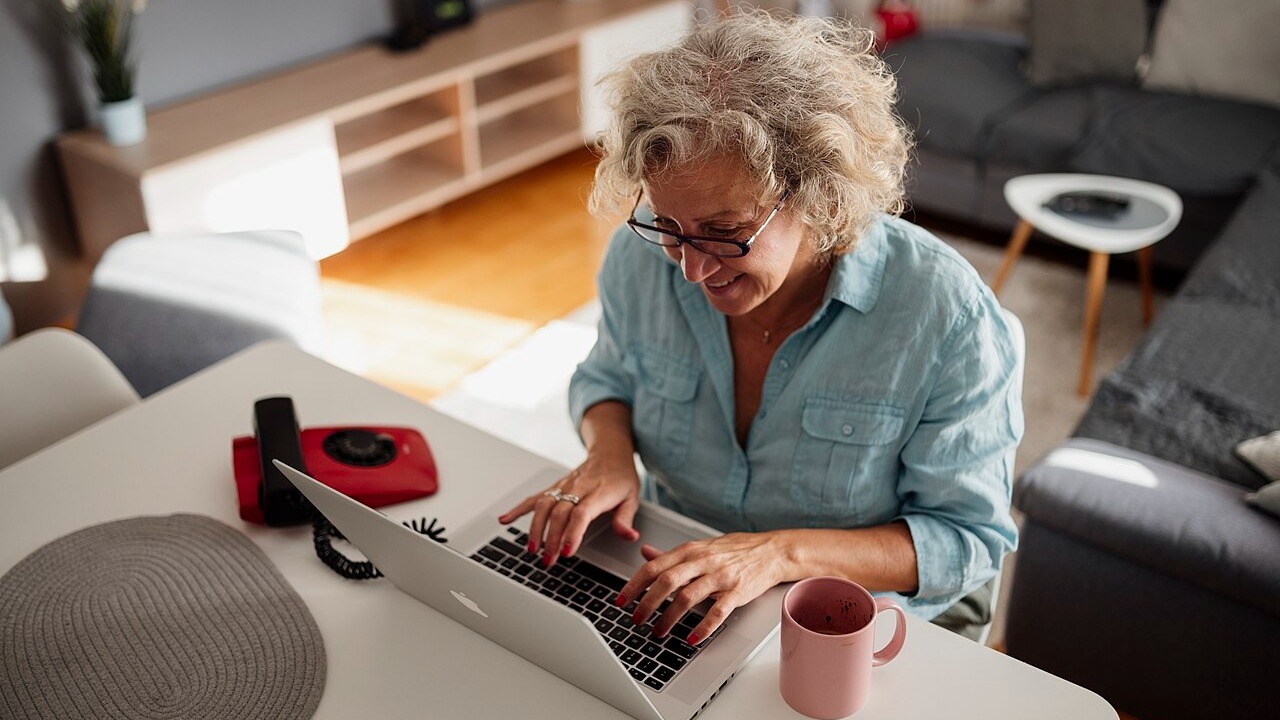 An older worker at a laptop at home