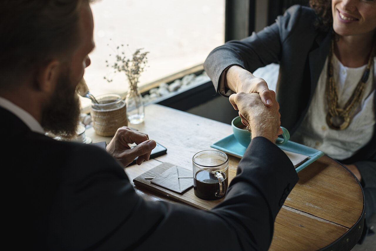 Two people shaking hands over a business agreement