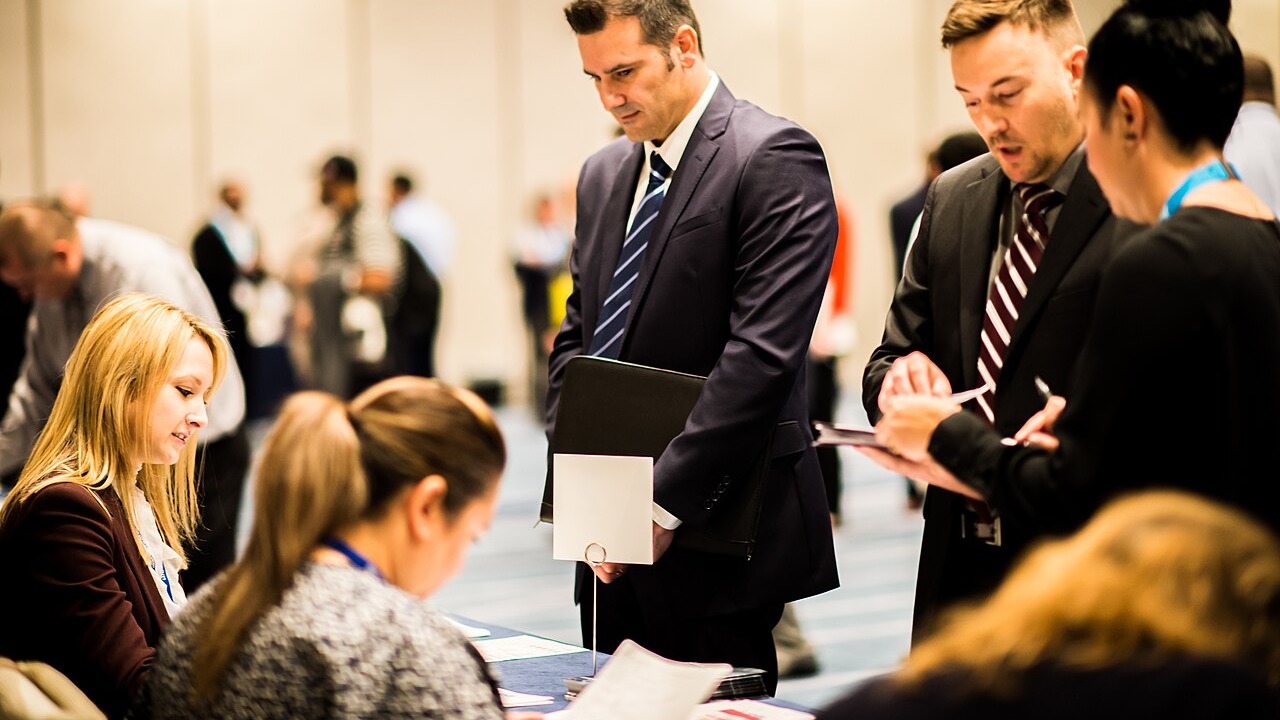 Job seekers talk with recruiters at a hiring fair