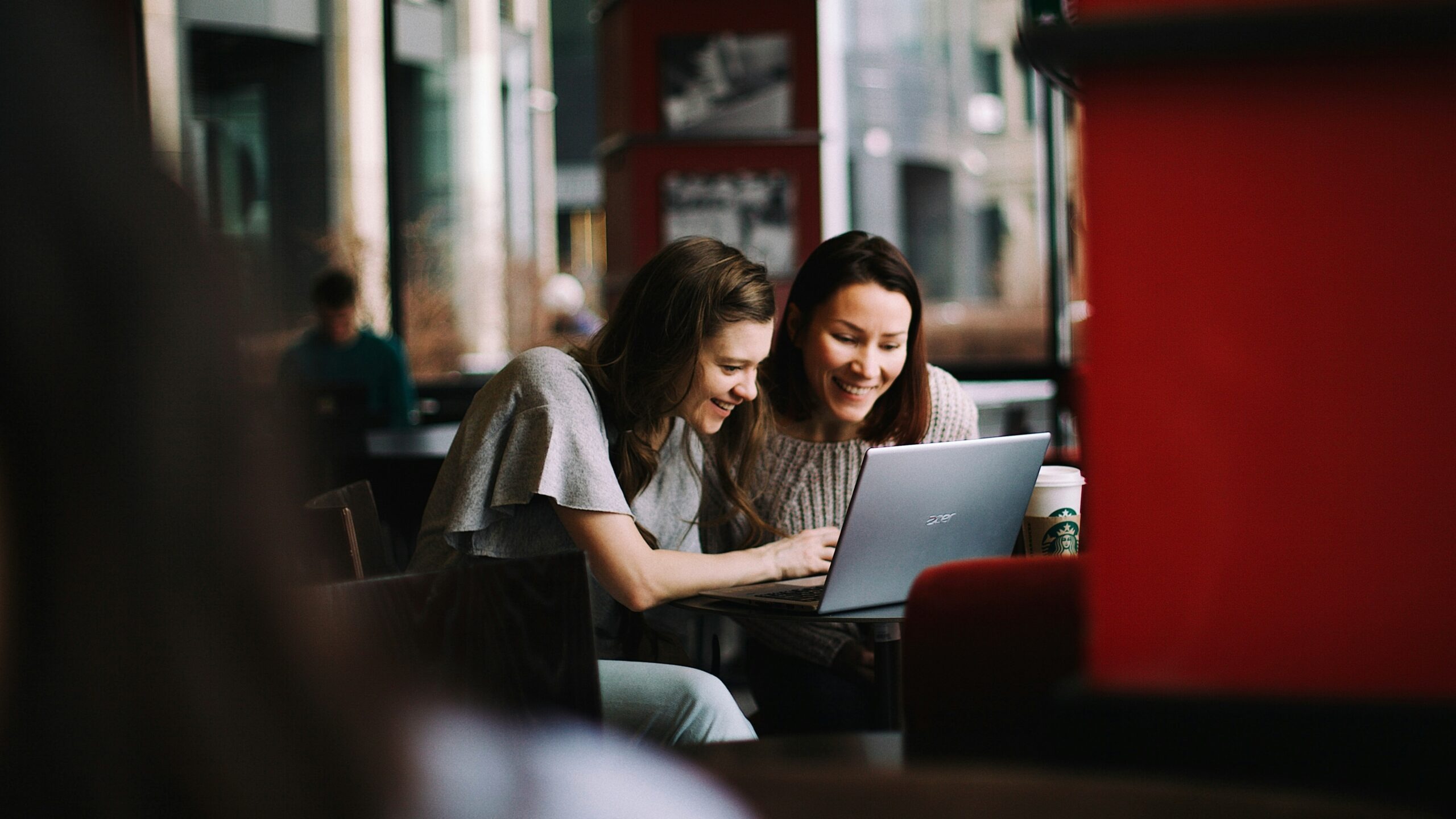 woman in white shirt using macbook