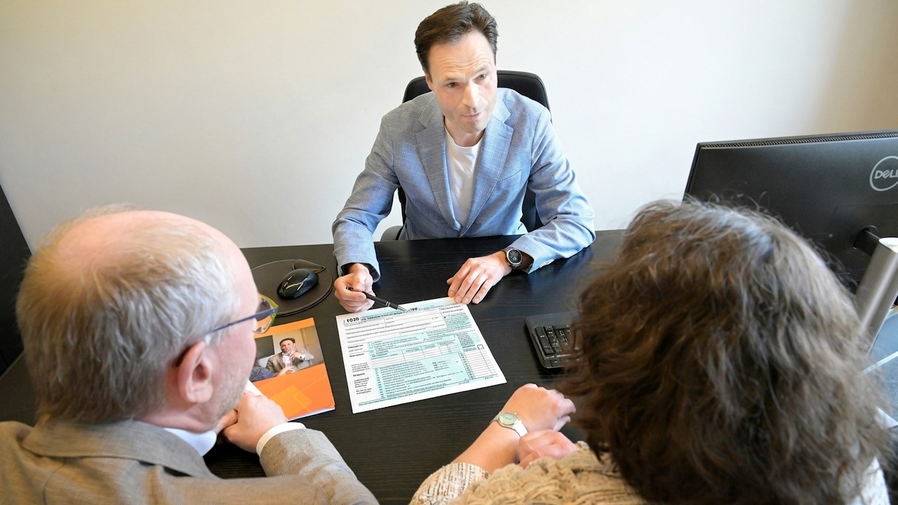 Consultant explains plans to a couple during a business meeting.