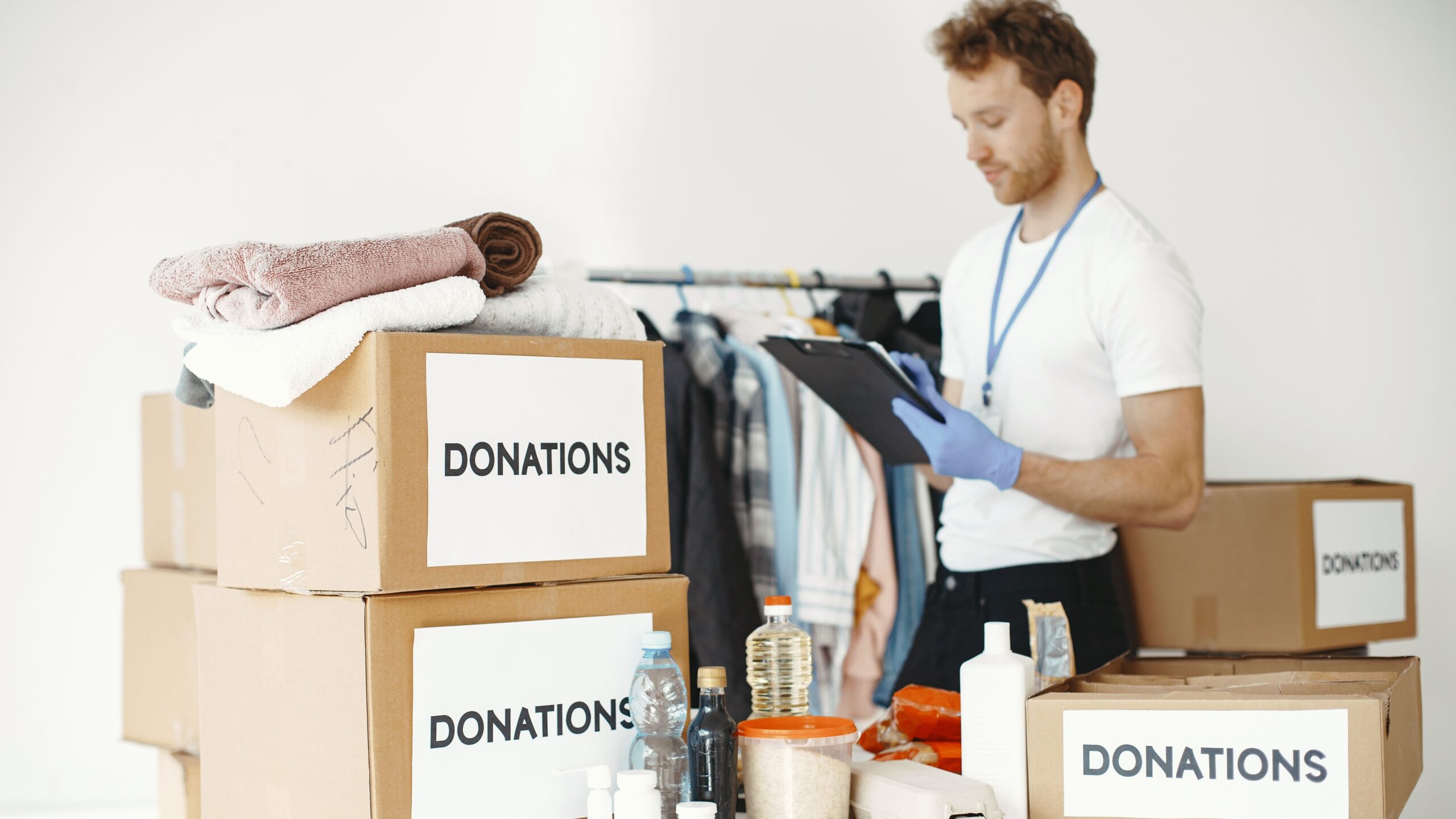 Volunteer organizing various goods for donation. Charitable cause and community support.