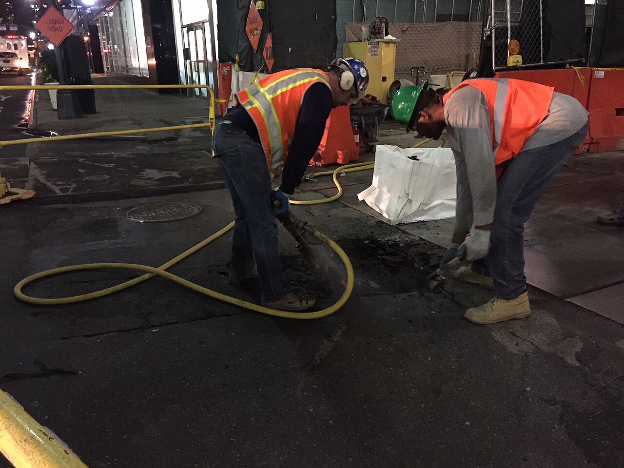 Workers digging up a street for a water main replacement