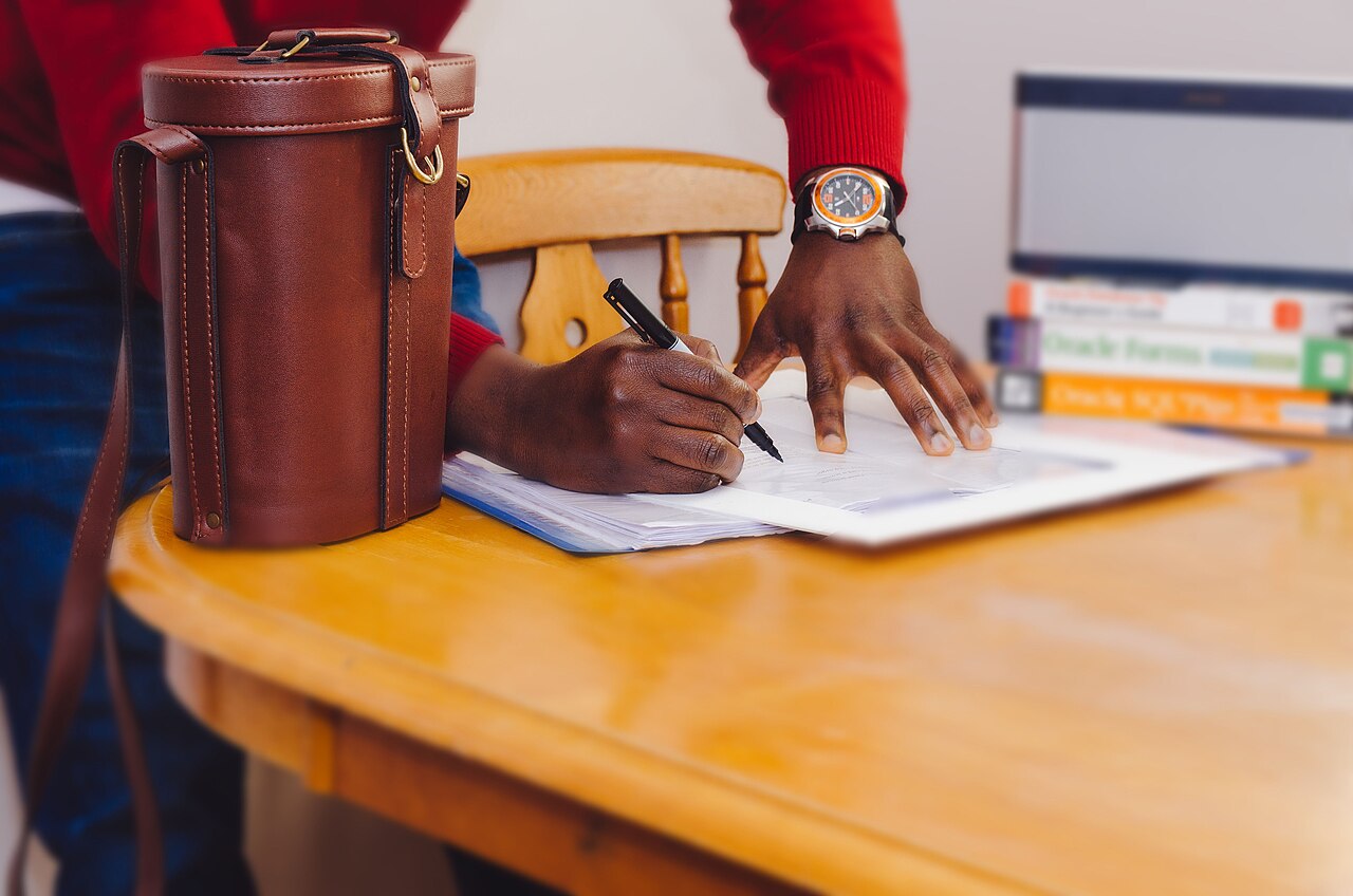 A person filling out a form by hand