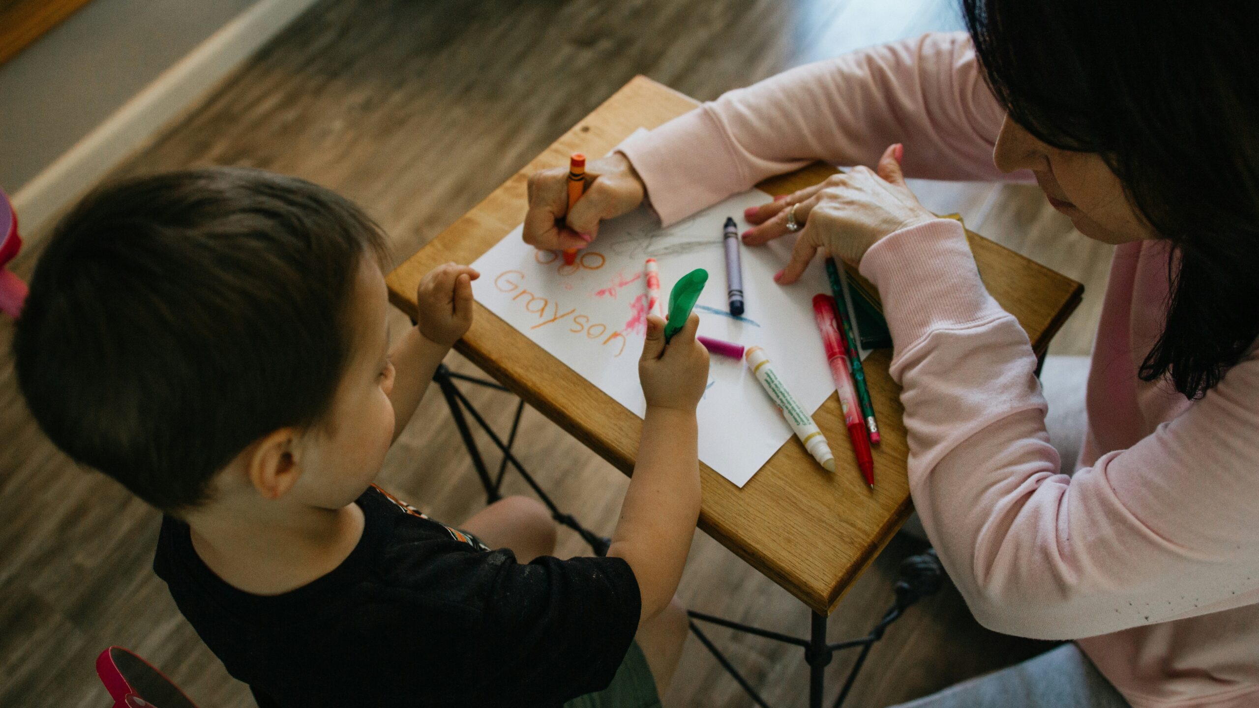 adult and child coloring at table