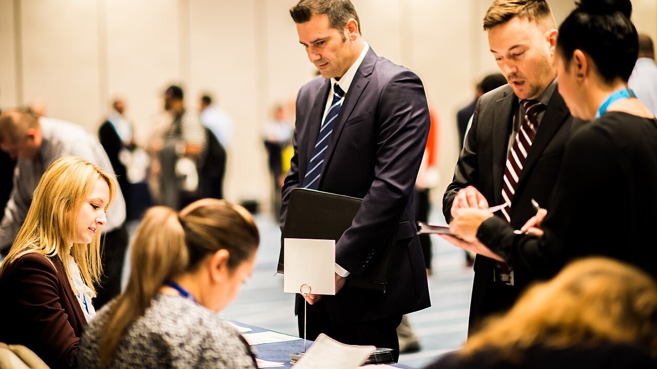 Job seekers talk with recruiters at a hiring fair