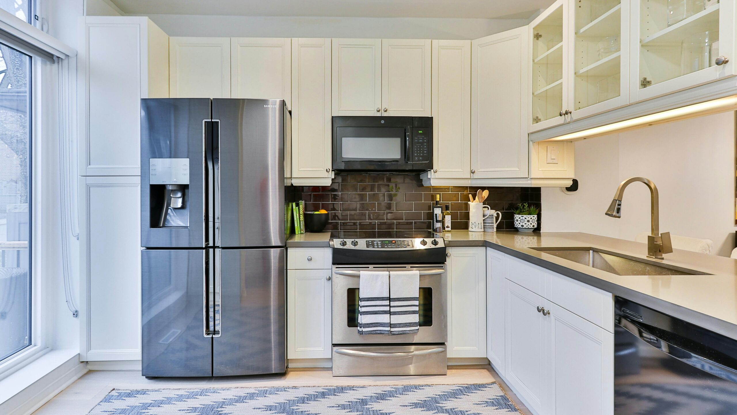 silver french door refrigerator beside white wooden kitchen cabinet