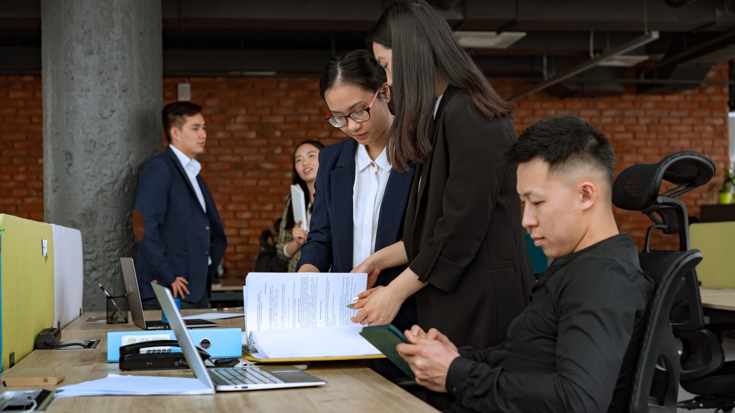 Professional team engaged in discussion and collaboration in a modern office environment.