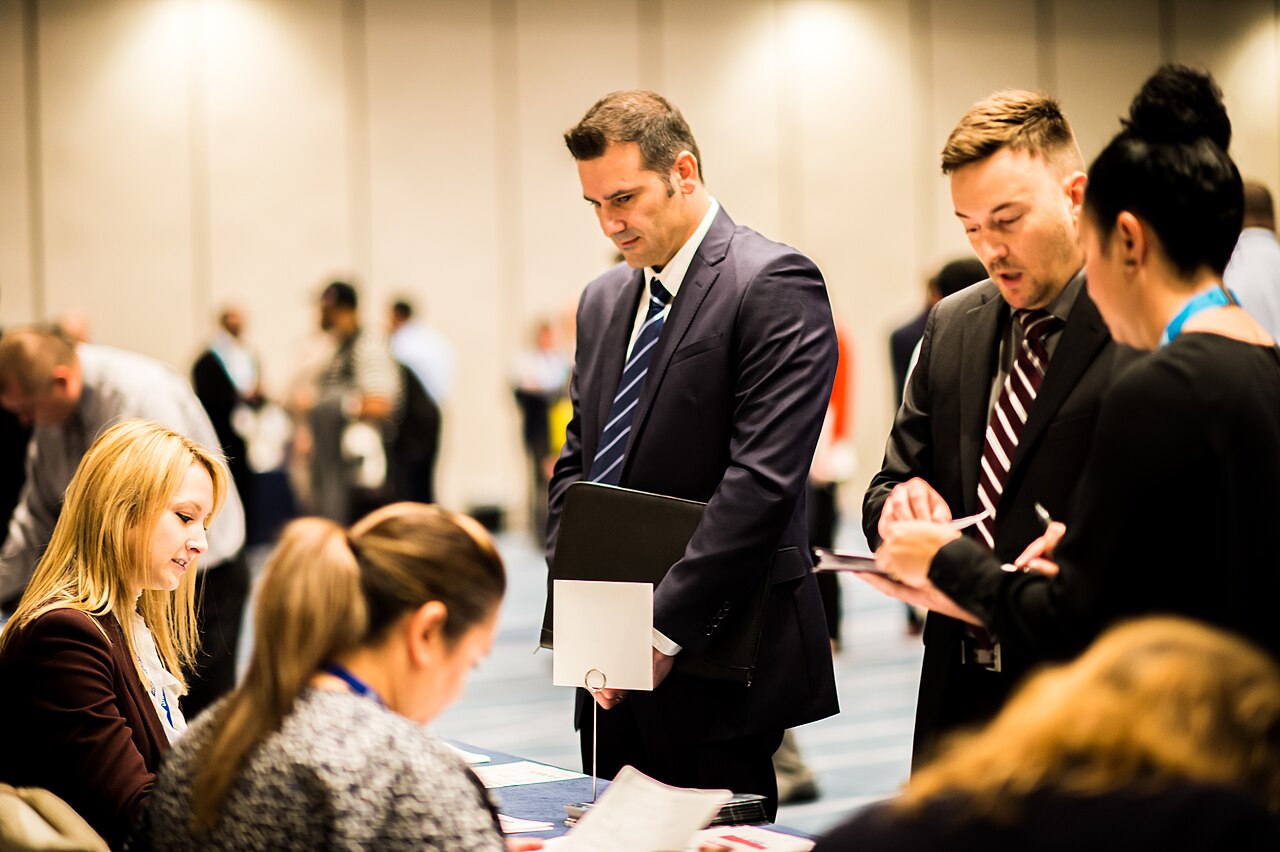 Job seekers talk with recruiters at a hiring fair